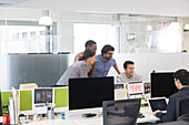 Business people meeting at computer in open plan office