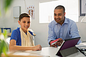 Male doctor prescribing medication to boy