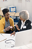 Doctor meeting with patient at computer in doctors office