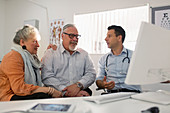 Doctor meeting with senior couple at computer