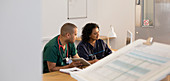 Male nurse and receptionist using computer in clinic