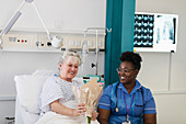 Female patient showing flowers to nurse in hospital room