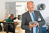 Male administrator using digital tablet in clinic