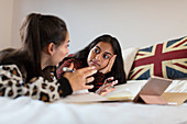 Teenage girls studying, talking on bed