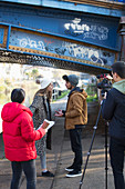 College film students filming under urban bridge