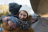 Portrait happy young woman hugging boyfriend