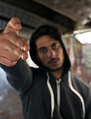 Portrait threatening young man gesturing finger gun