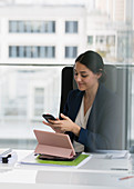 Businesswoman using smart phone in conference room