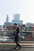 Businessman using smart phone on highrise balcony