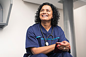 Portrait happy female doctor using smart phone