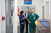 Male surgeon walking in hospital corridor