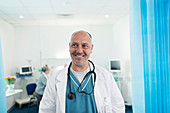 Portrait confident, male doctor in hospital room
