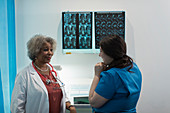 Female doctor and nurse discussing x-rays in in hospital