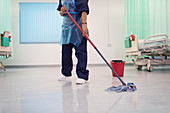 Female orderly mopping hospital ward floor