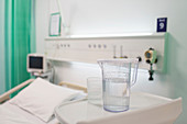 Water pitcher and glass on tray in vacant hospital room