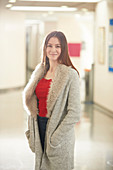 Portrait young female college student in corridor