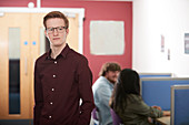 Portrait young male college student in library