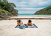Couple sunbathing on remote tropical ocean beach
