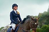Confident teenage girl equestrian horseback riding