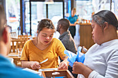 Young women with Down Syndrome cleaning silverware in cafe