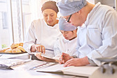 Chef and students with Down Syndrome looking at recipes