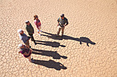 Guide talking with group on sunny cracked earth