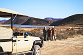 Senior friends on safari watching wildlife in distance