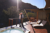 Senior couple on sunny luxury safari lodge hotel balcony
