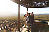 Senior friends on sunny safari lodge balcony South Africa