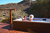 Senior couple relaxing in hot tub on sunny safari balcony