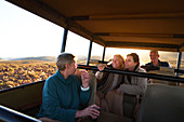 Senior friends riding in safari off-road vehicle