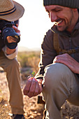 Guide explaining plant to man with digital camera