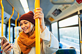 Woman texting with smart phone on bus