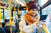 Woman using digital tablet on bus