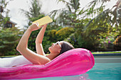 Woman reading book on inflatable raft