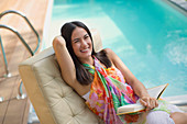 Woman reading book at summer poolside
