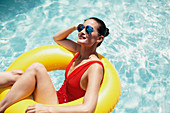 Woman in sunglasses relaxing in inflatable ring