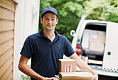 Portrait deliveryman with packages at front door