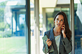 Businesswoman talking on cell phone in corridor