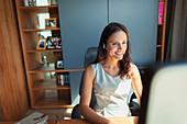Smiling businesswoman with headset working in home office