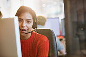 Businesswoman in headset working at computer in office