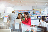Businesswomen using digital tablet in open plan office
