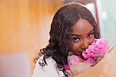 Portrait beautiful woman smelling fresh pink peony bouquet