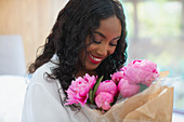 Woman receiving pink peony bouquet