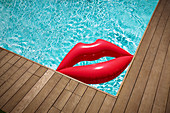 Inflatable lips floating in summer swimming pool