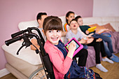 Happy girl in wheelchair using digital tablet