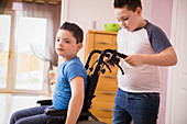 Boy pushing brother with Down Syndrome in wheelchair