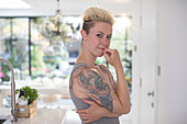 Woman with tattoos in kitchen