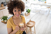 Woman drinking cappuccino in kitchen