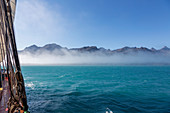 Scenic view fog clearing over mountain range Greenland